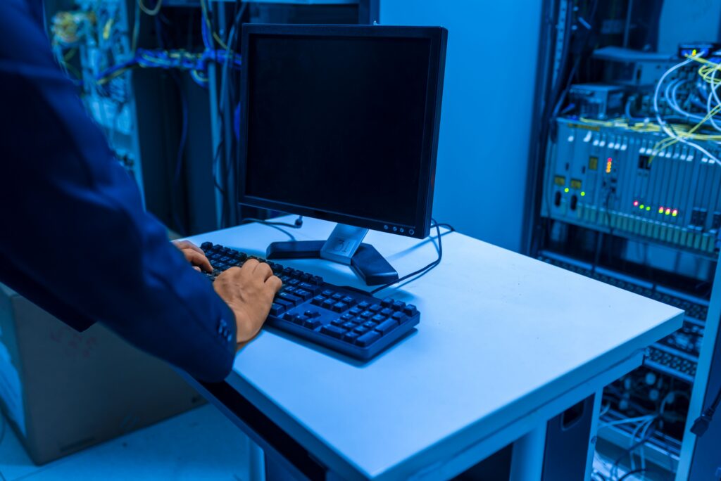 En tekniker arbetar vid en dator i ett serverrum med nätverksutrustning