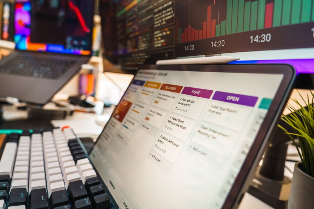 Arbetsplats med flera skärmar som visar data och projektverktyg